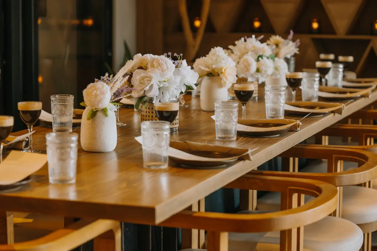 A long table at CALA set with white flowers, plates and drinks for a private event